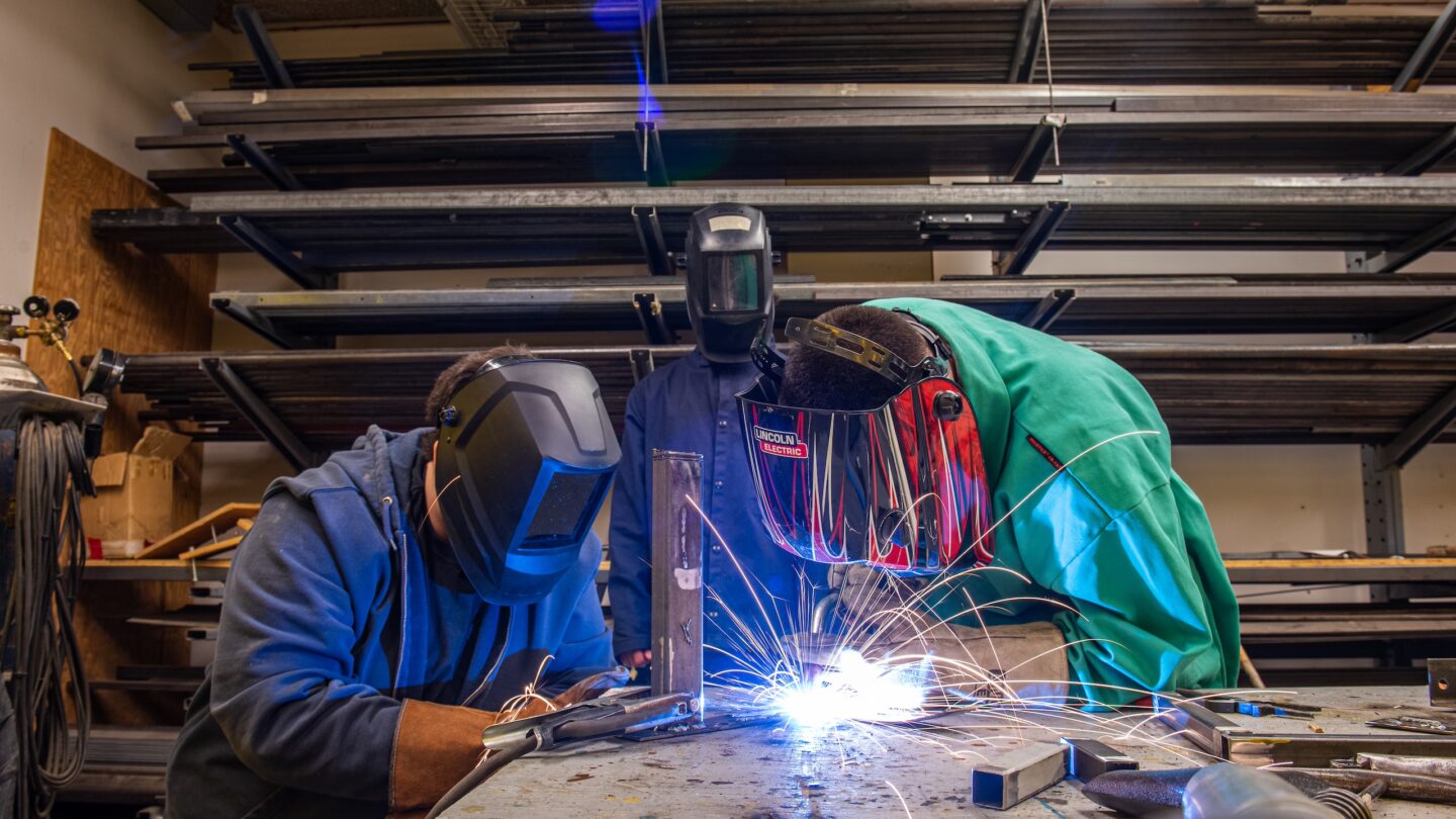 Students weld in the scene shop