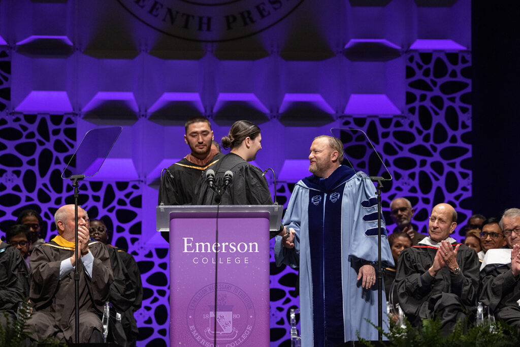 Dr. Jay Bernhardt shakes the hand of Fiona Brown ’26 after she gave an official greeting to the president on behalf of undergraduate students. Graduate student representative Joseph Weingrad, MFA ’25 waits to speak.