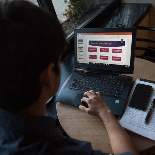 Student looks at campaign blueprint on laptop