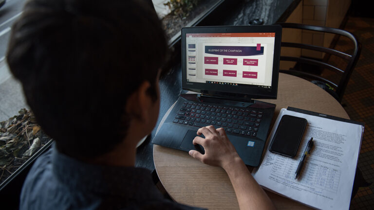 Student looks at campaign blueprint on laptop