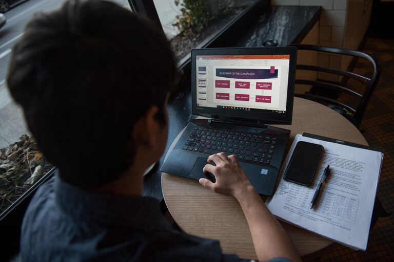 Student looks at campaign blueprint on laptop