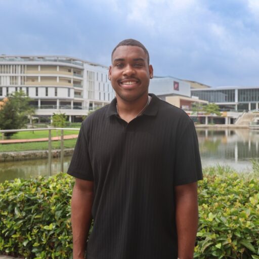 Man stands in front of canal, buildings