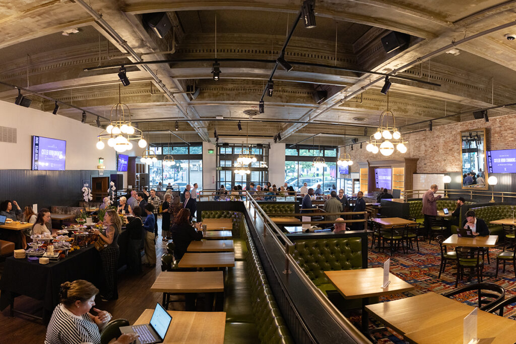 fisheye lens photo of a large gathering space with booths, tables, and a bar