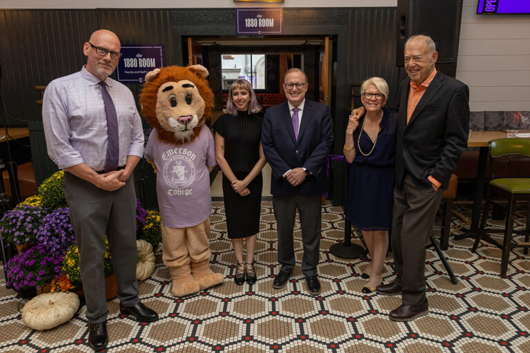 Five people and a person in a lion costume pose for a photo