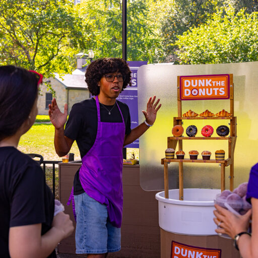 Armando Barbosa speaks in front of a shelf of fake pastries