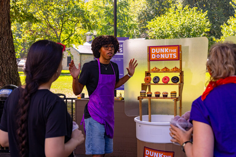Armando Barbosa speaks in front of a shelf of fake pastries