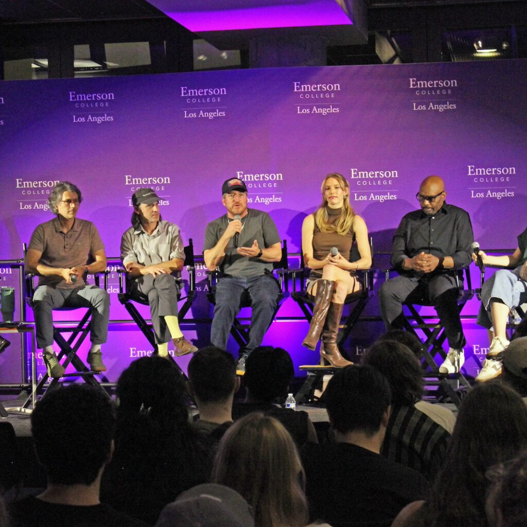 Alumni panelists sit in chairs on a stage at ELA