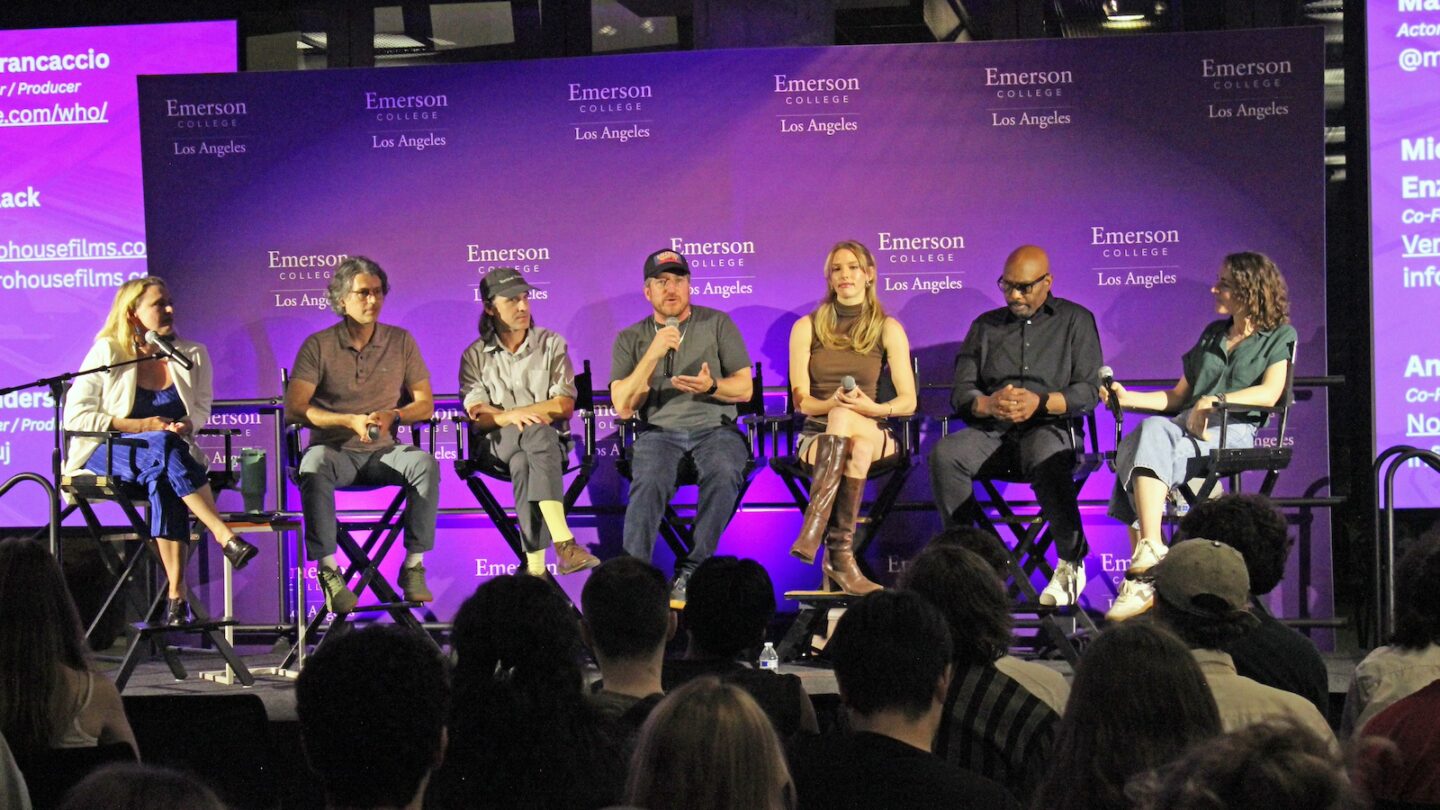 Alumni panelists sit in chairs on a stage at ELA