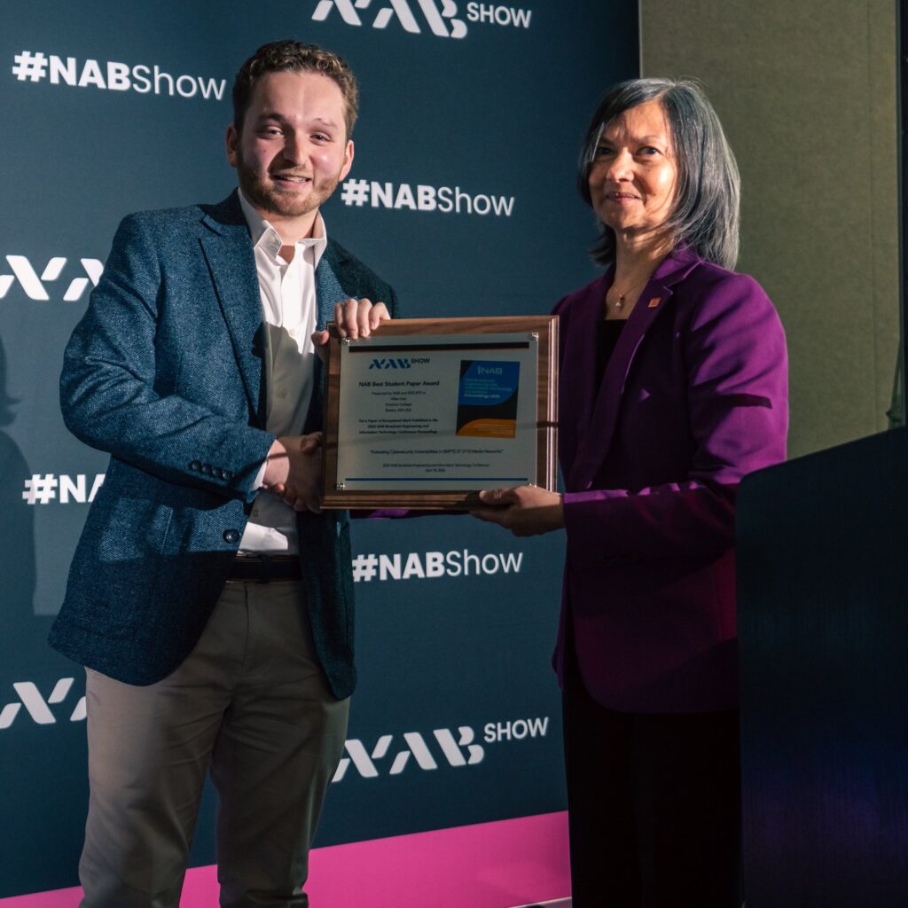 Miles Katz receives an award from a person