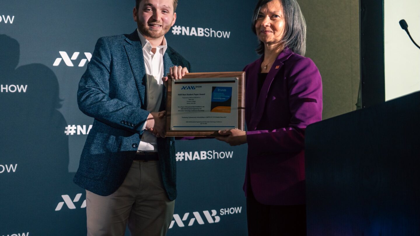 Miles Katz receives an award from a person
