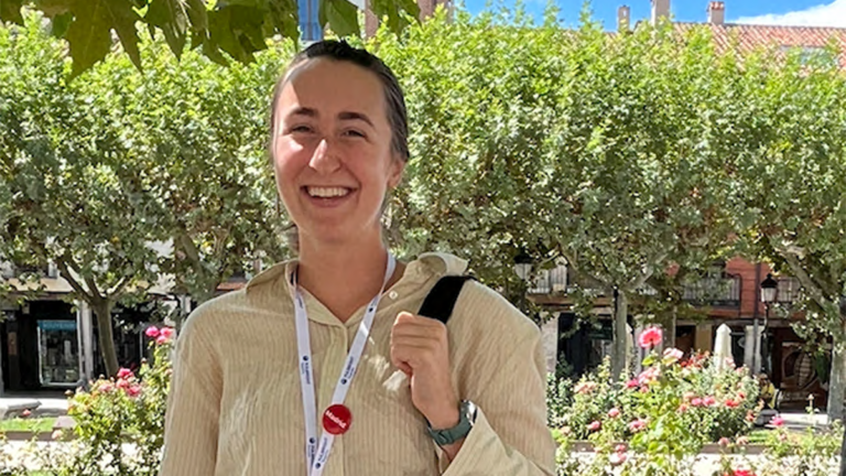 Katherine Holmes in front of building with flowers