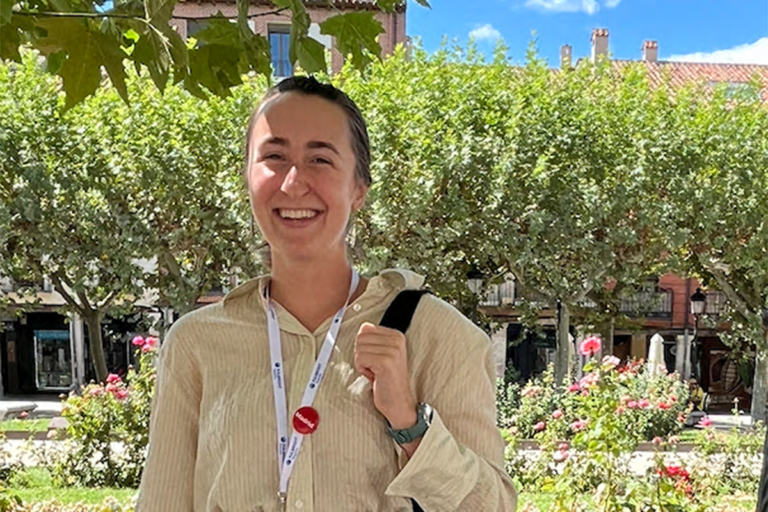 Katherine Holmes in front of building with flowers