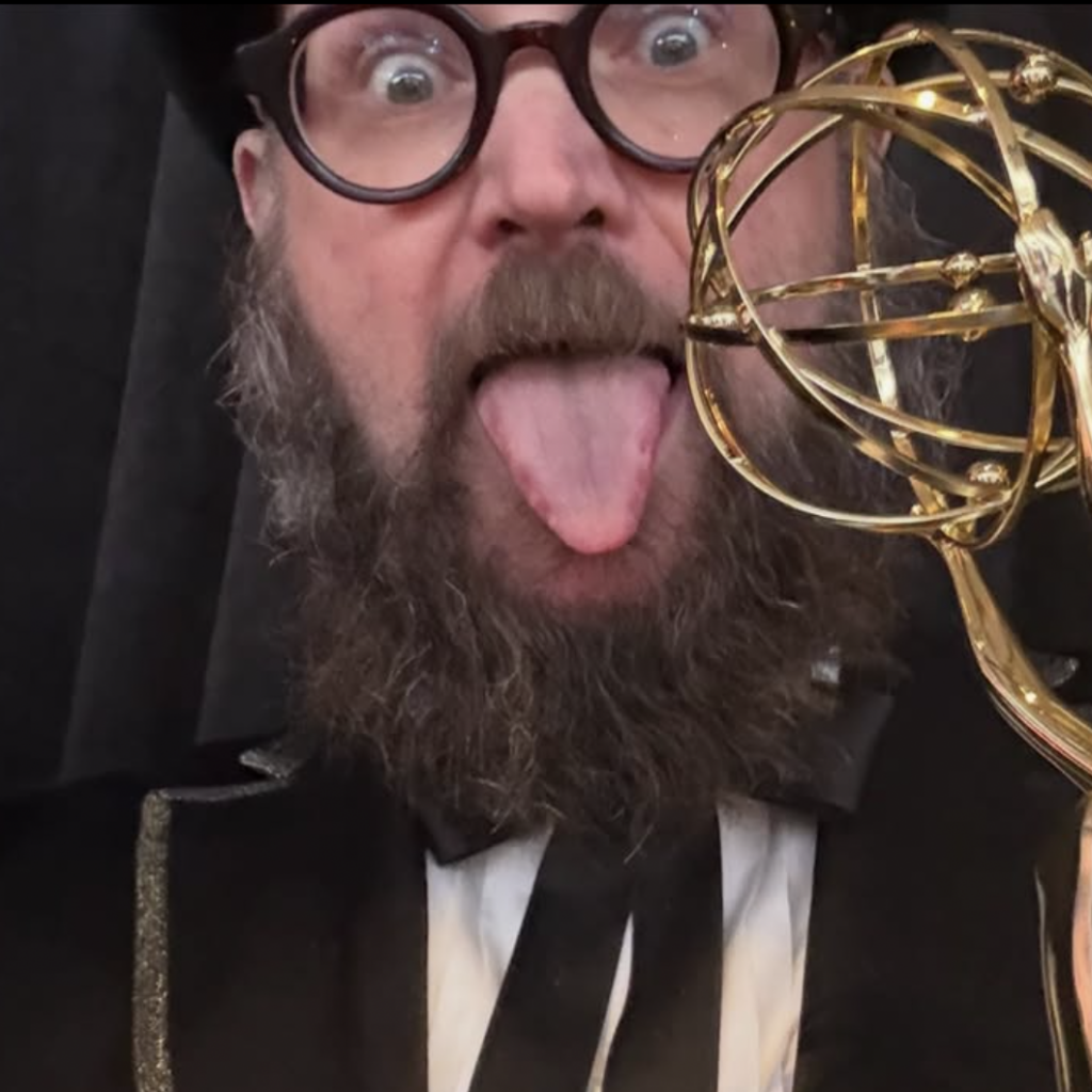 Opus Moreschi sticks out his tongue while holding an Emmy Award