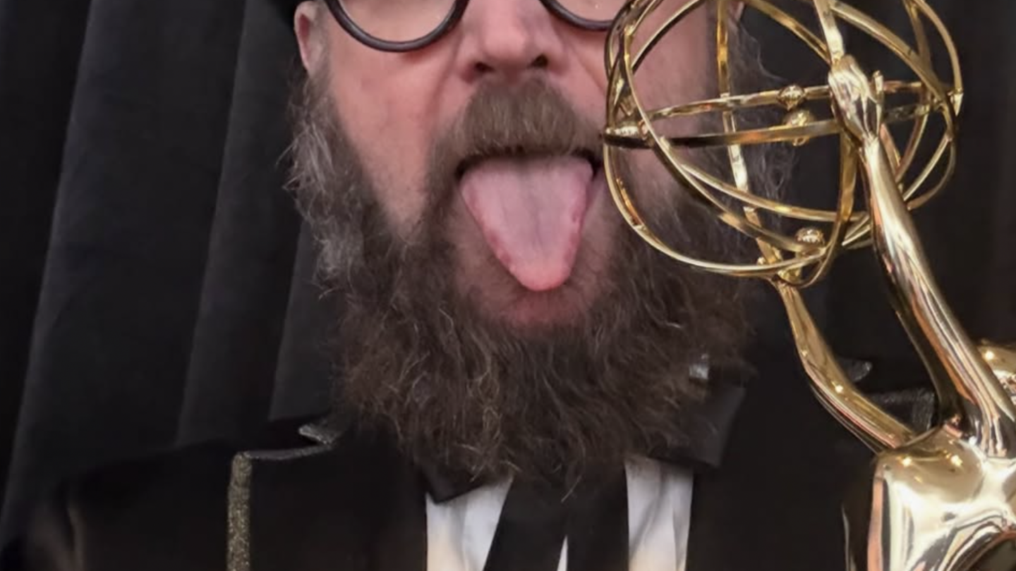 Opus Moreschi sticks out his tongue while holding an Emmy Award