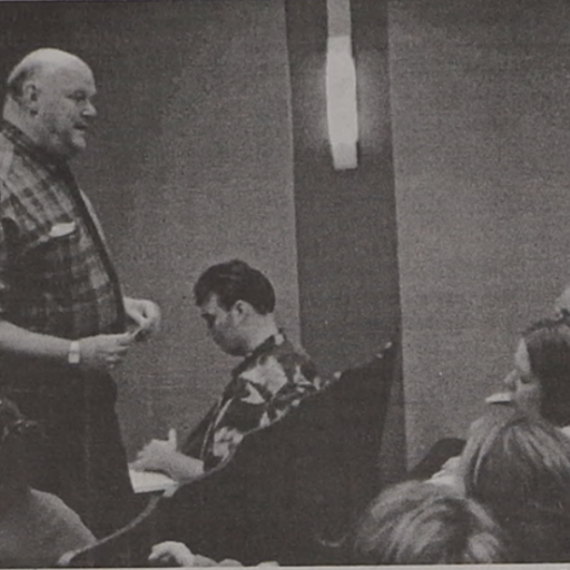 Black and white photo of Rabbi Axelrad talking to students