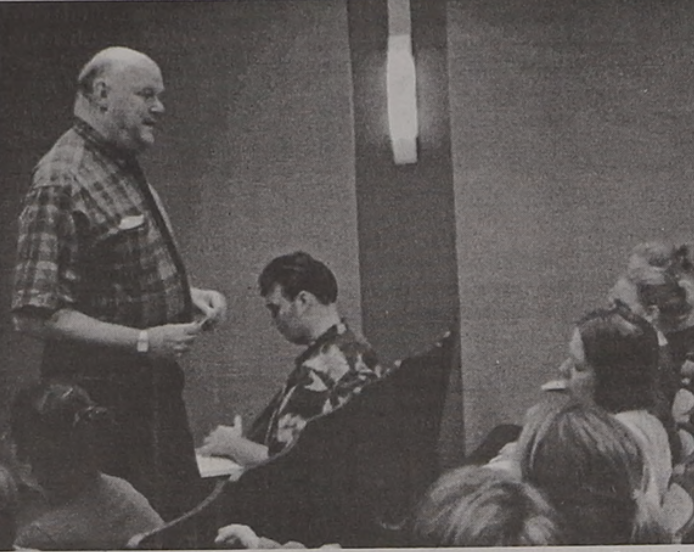 Black and white photo of Rabbi Axelrad talking to students