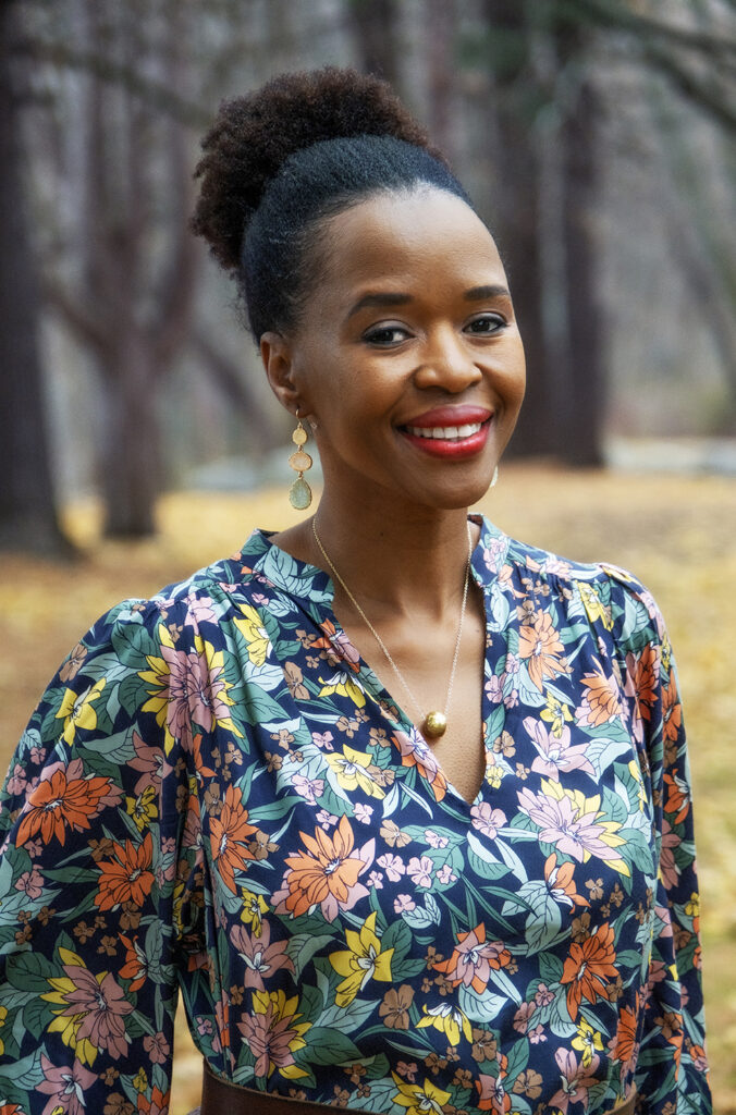 A smiling person in a colorful shirt poses for a photo.