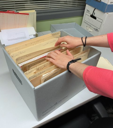 Someone goes through a box of folders