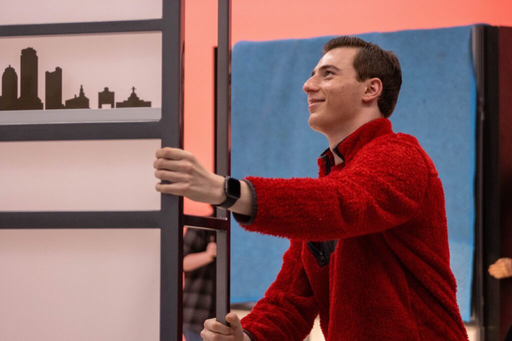 A person moves something behind the scenes before the live show