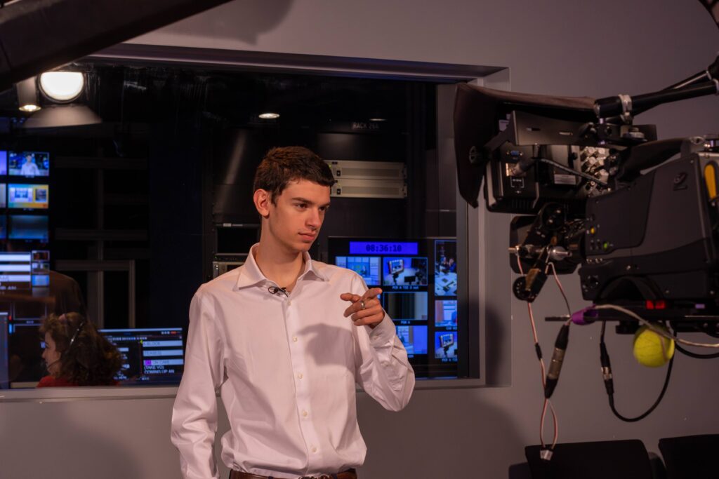 A person points to on-air talent