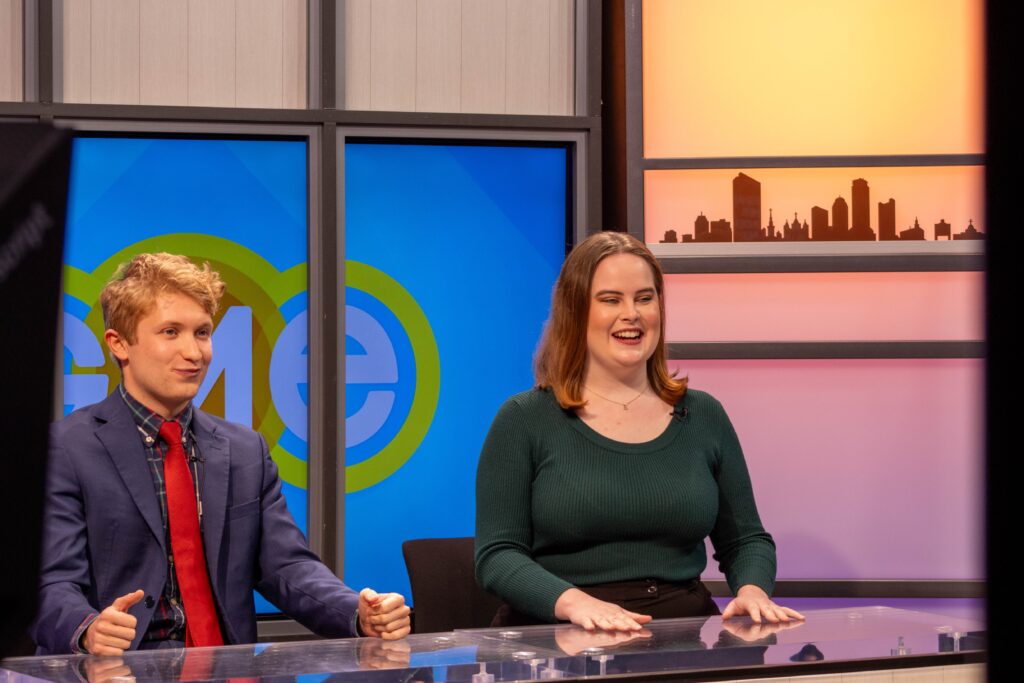 The co-hosts sit at a table