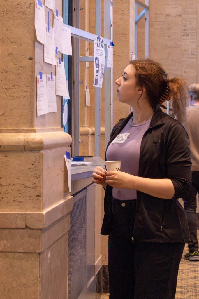 A person reviews notes posted on the wall
