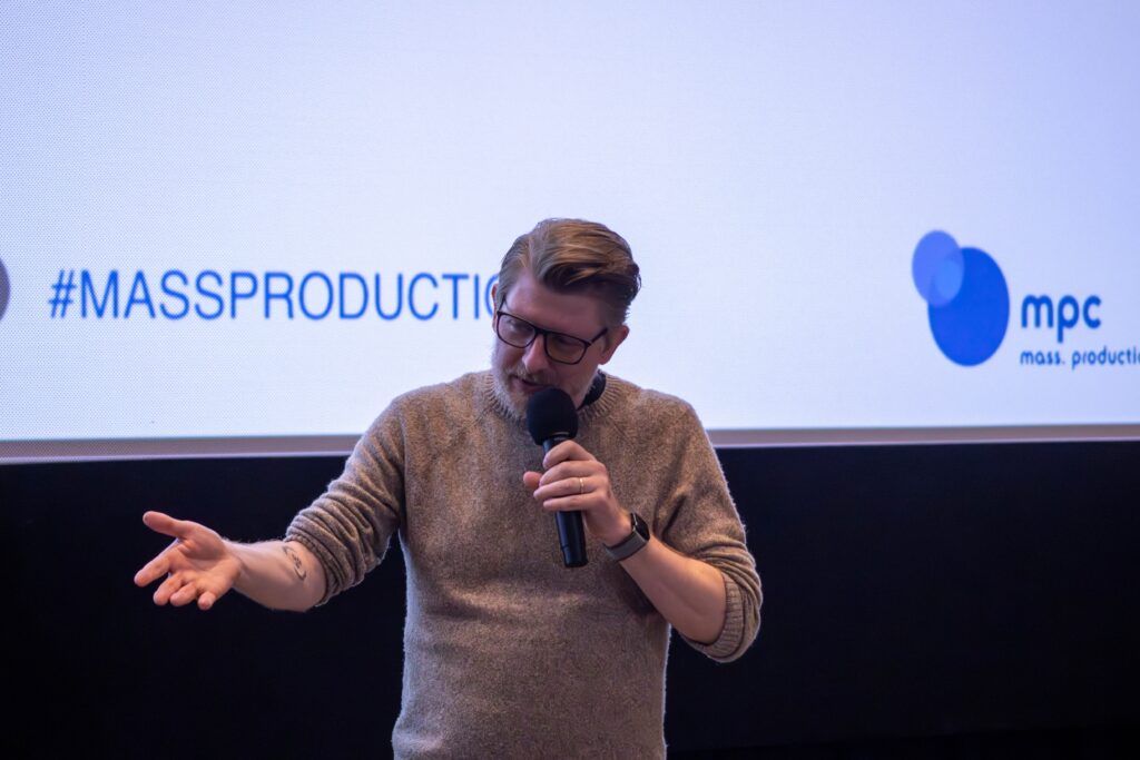 Matt Nash speaks to the audience while holding a microphone