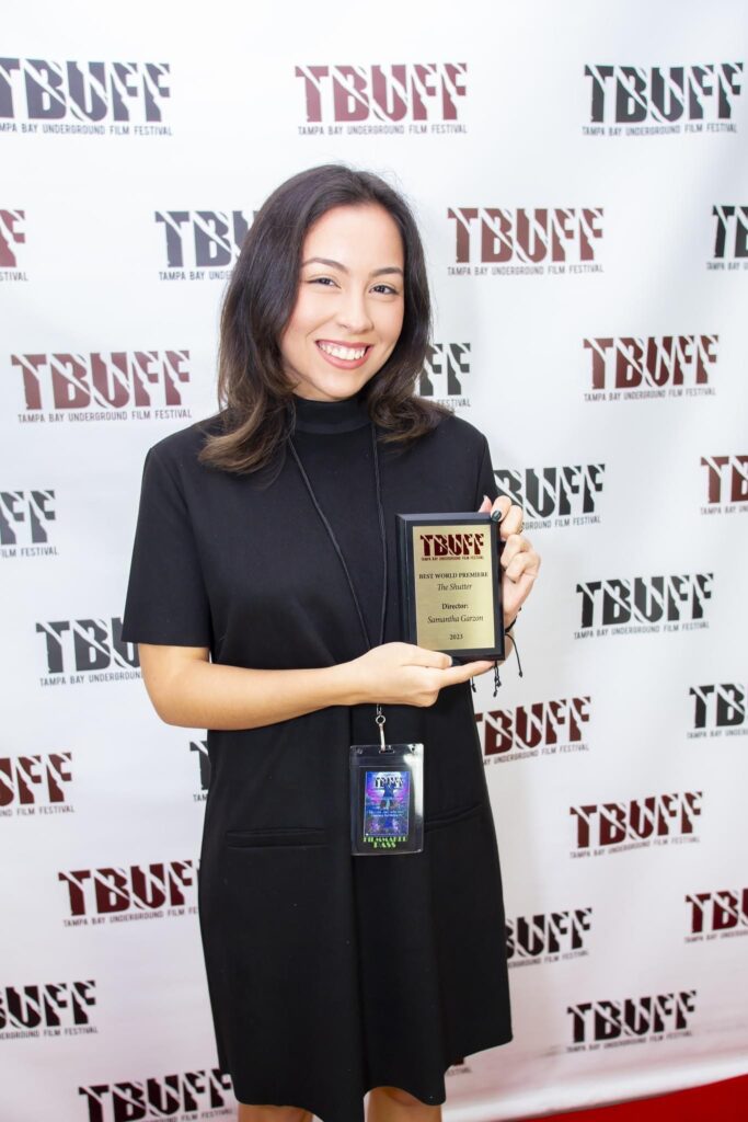 Samantha Garzon holds a little plaque