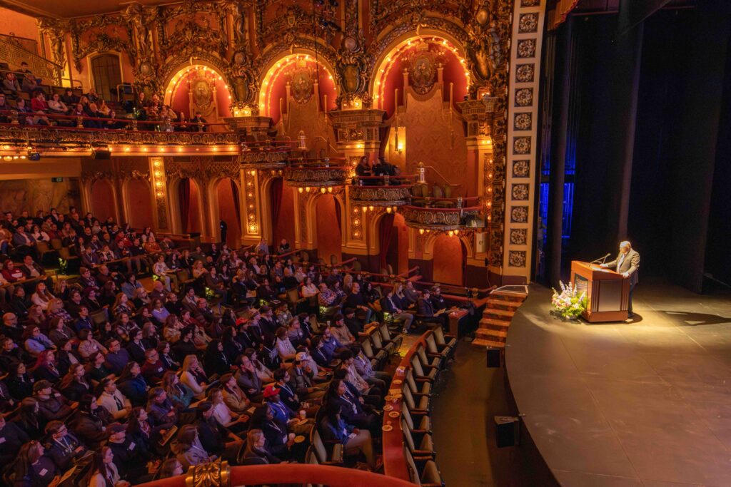 A faraway view of Dr. Jay Bernhardt talking to an audience in the Majestic Theatre