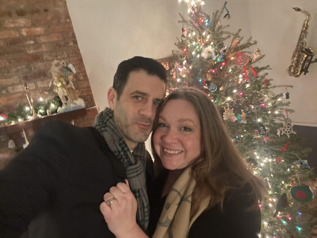 Patrick Zeller and Emily Zeller in front of a Christmas tree