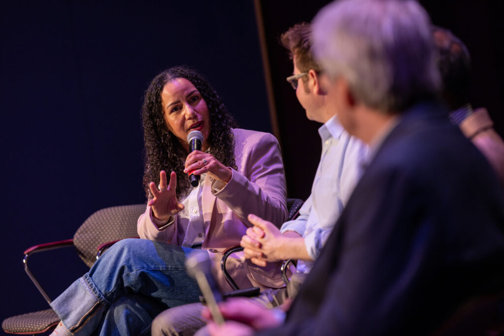 Kyanna Sutton sits while speaking and holding a microphone