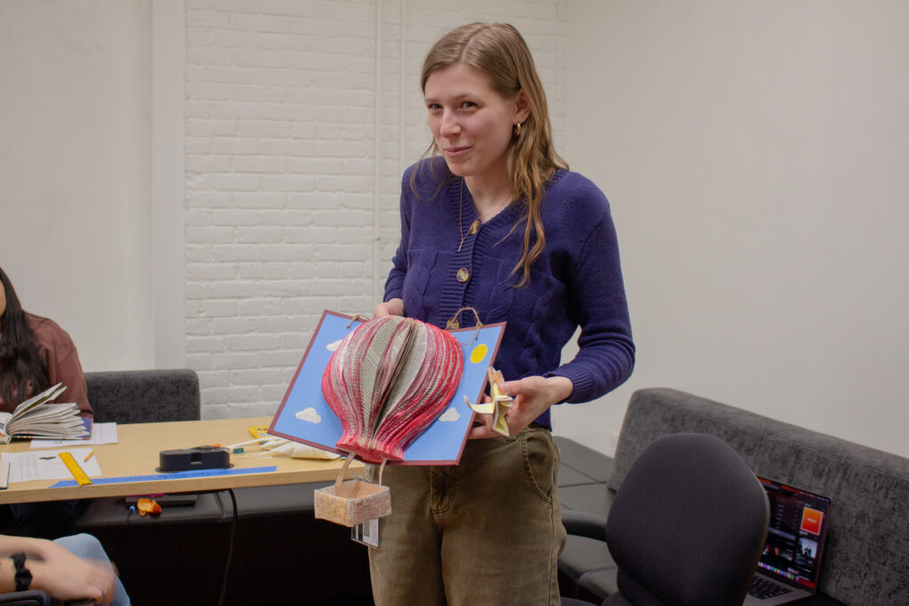 Elizabeth Apple displays upcycled book art that they made