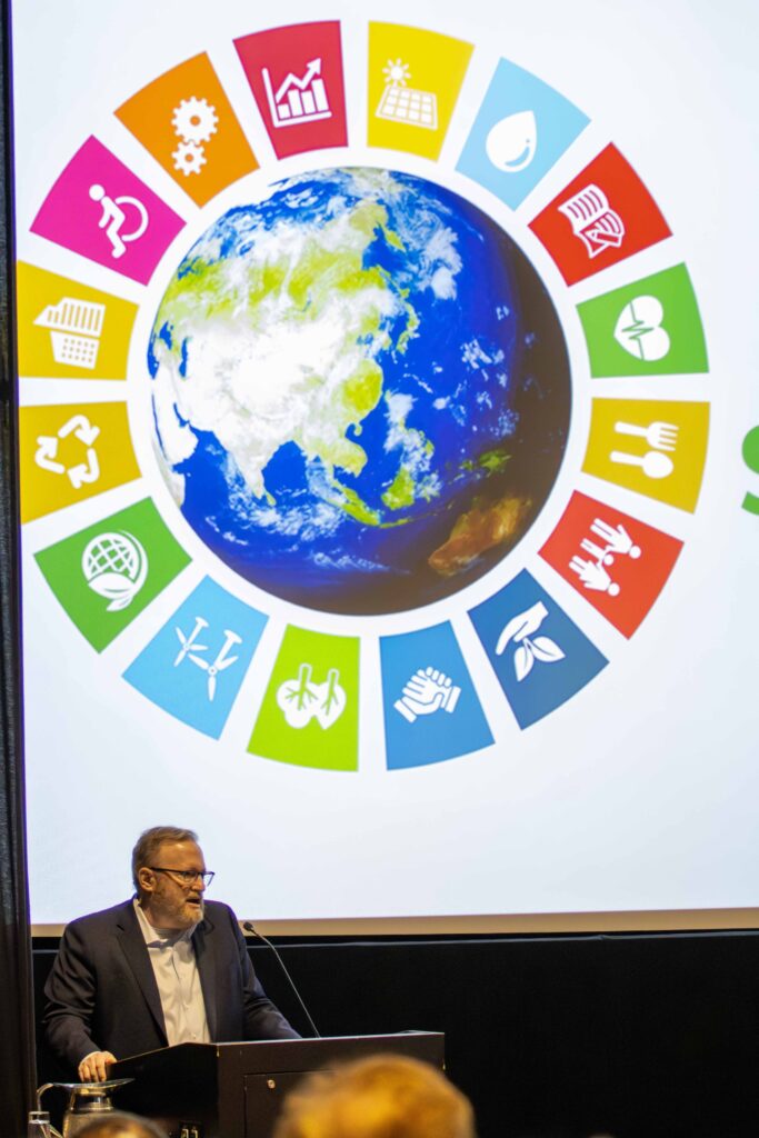 Dr. Jay Bernhardt speaks at a lectern 