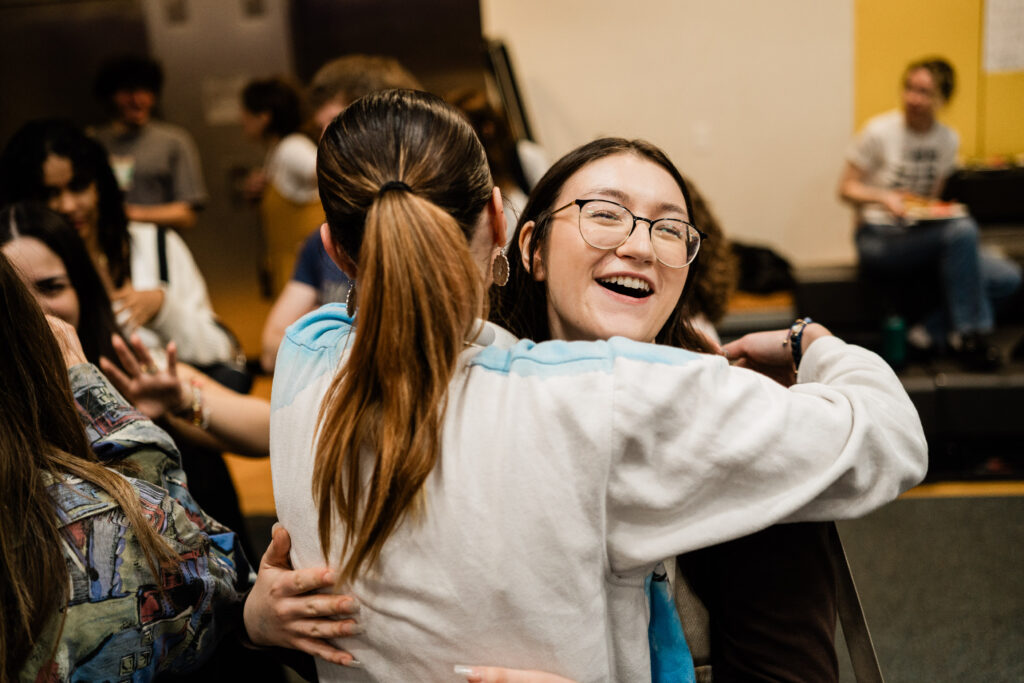 Someone smiles as they hug someone else