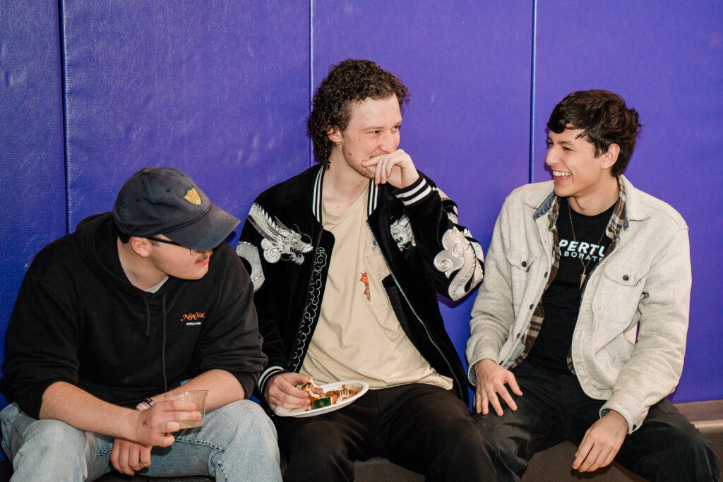 Three people sit together laughing