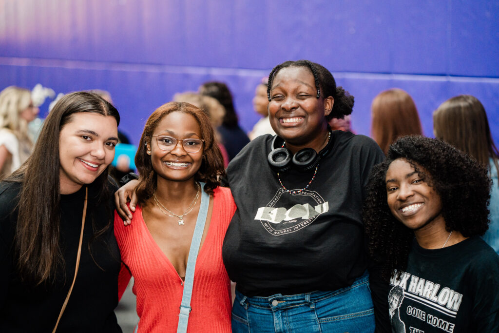 Four people pose for the camera with arms around each other