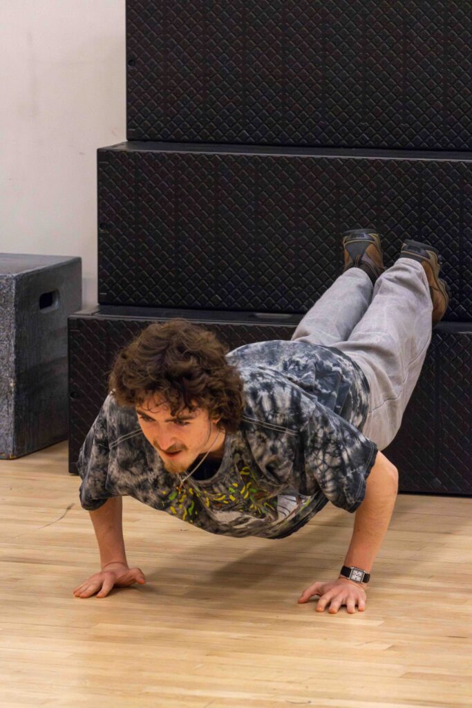 A student does a pushup with his feet up two levels of stairs