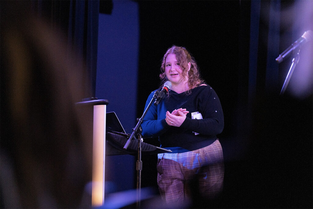 A person reads their work to the audience