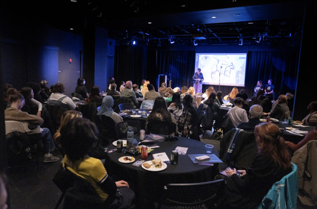 The audience sat at tables and chairs