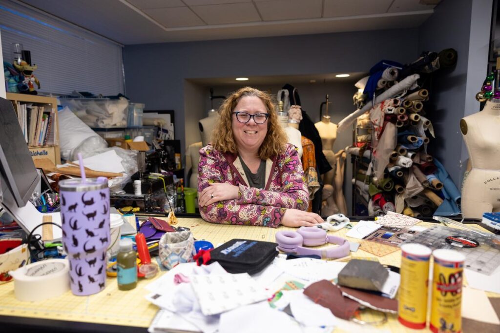 Richelle Devereaux Murray sits at a sewing table