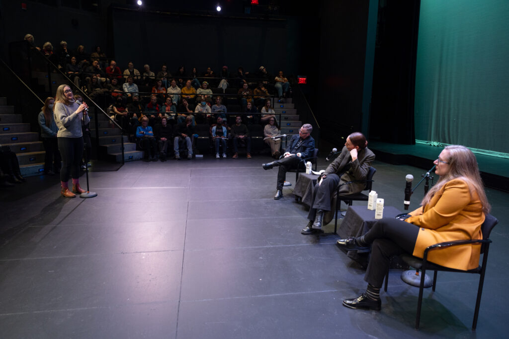 Sarah Ruhl, Jacinda Ardern and P. Carl are sitting while someone asks a question on stage