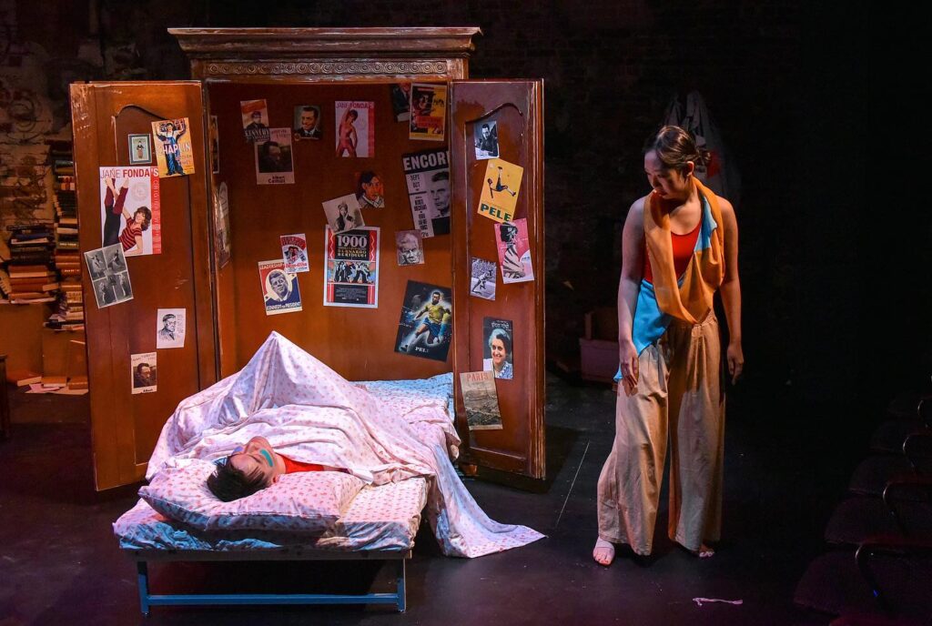 Two people perform on stage as part of the play