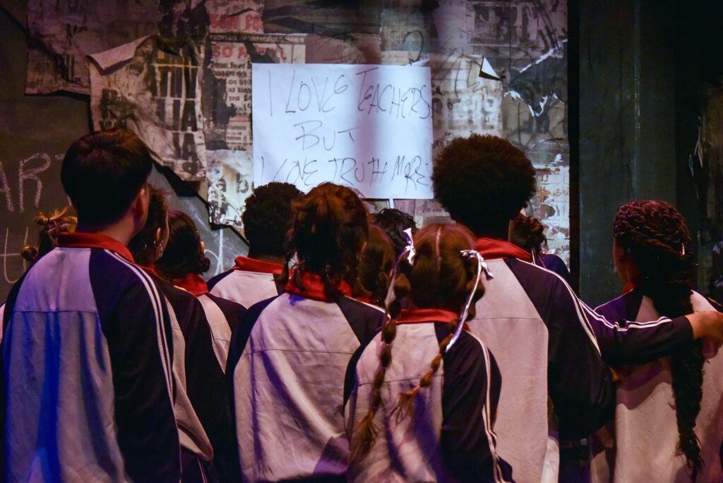 The backs of a group of actors in tracksuits 