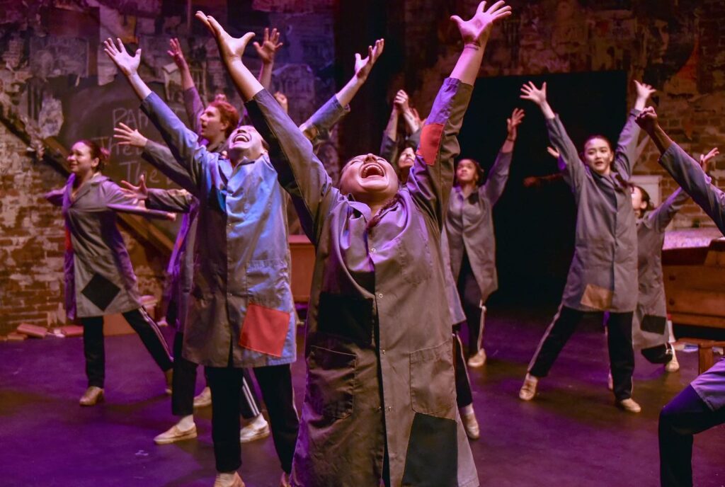 The cast lift up their hands in adulation