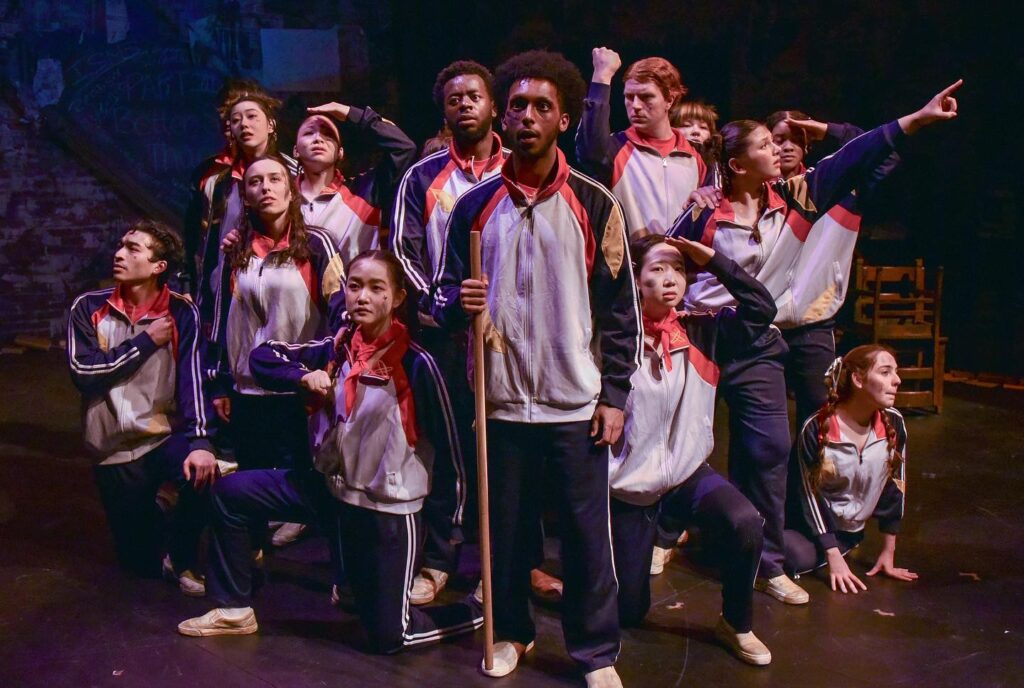 A group of actors wearing tracksuits during the play
