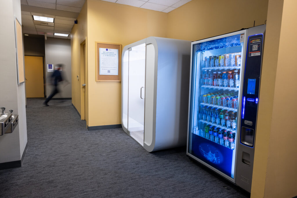 The photo booth is in a corner next to a vending machine