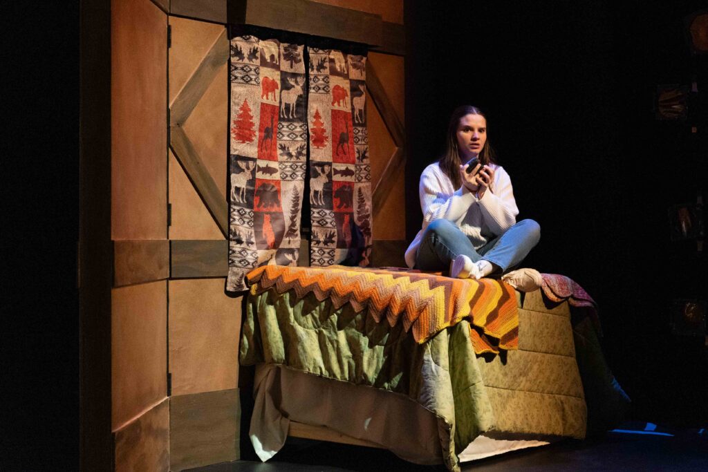 A character sits on her bed listening to a tape recording