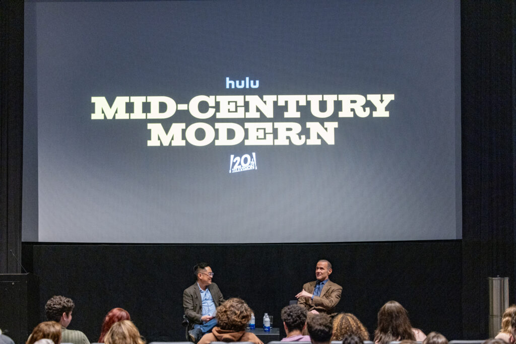 Ed Lee and Max Mutchnik sit under a large TV screen that says Mid-Century Modern