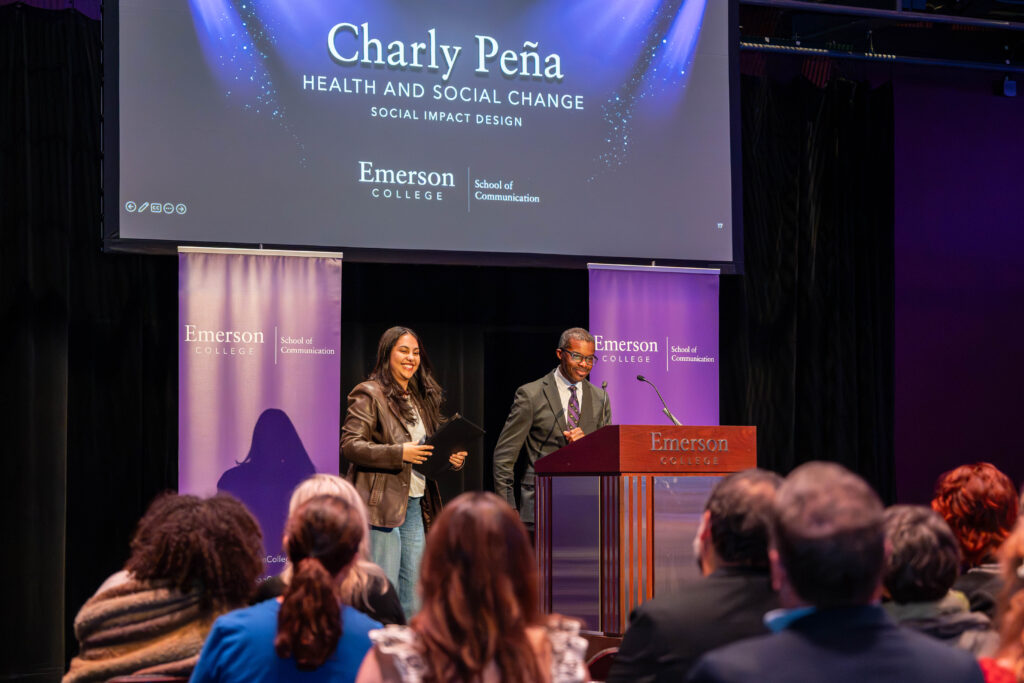 Brent Smith and a students smile on stage as he announces her award.