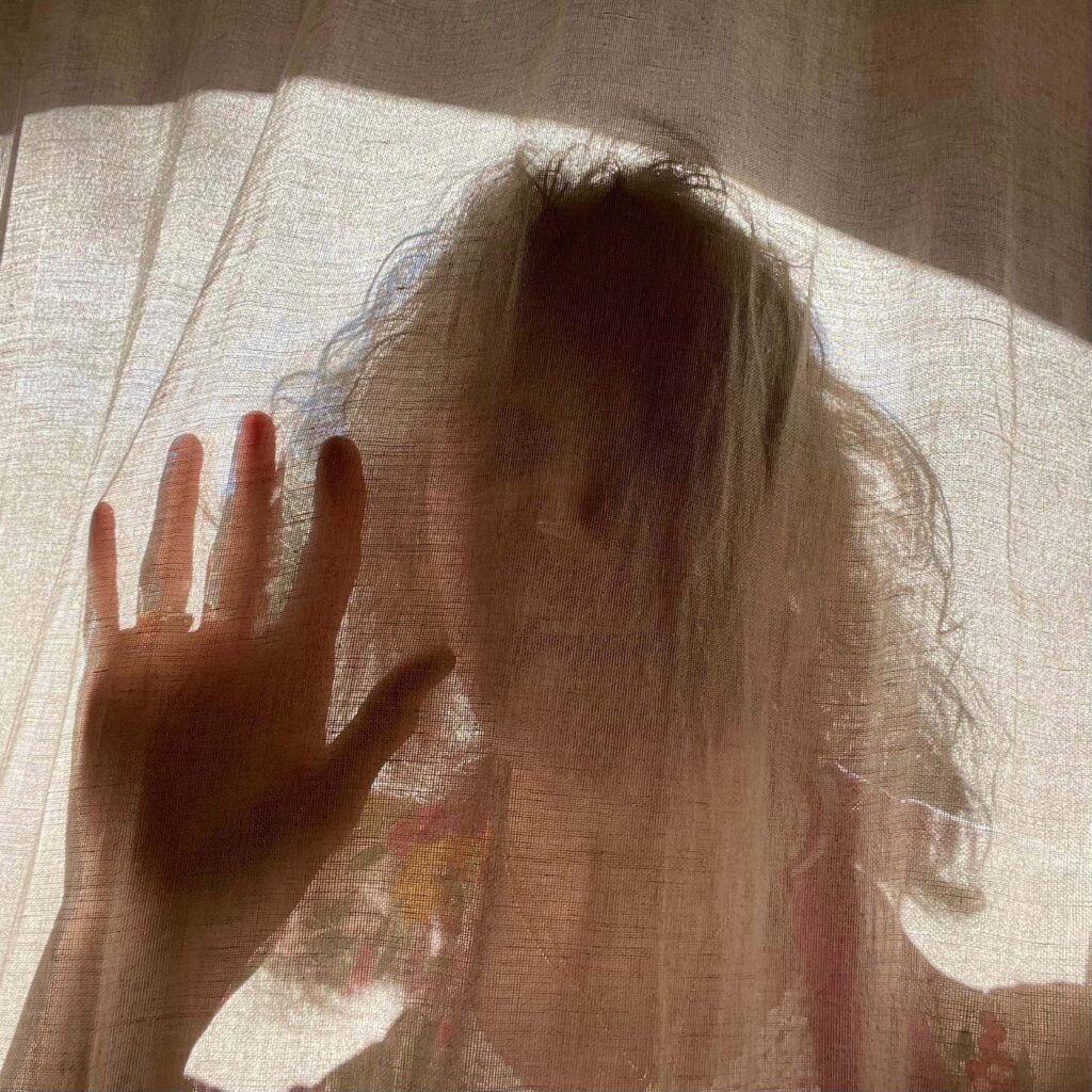 A person seen behind a transparent sheet